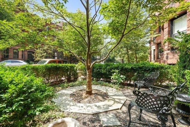 a view of backyard with table and chairs and potted plants