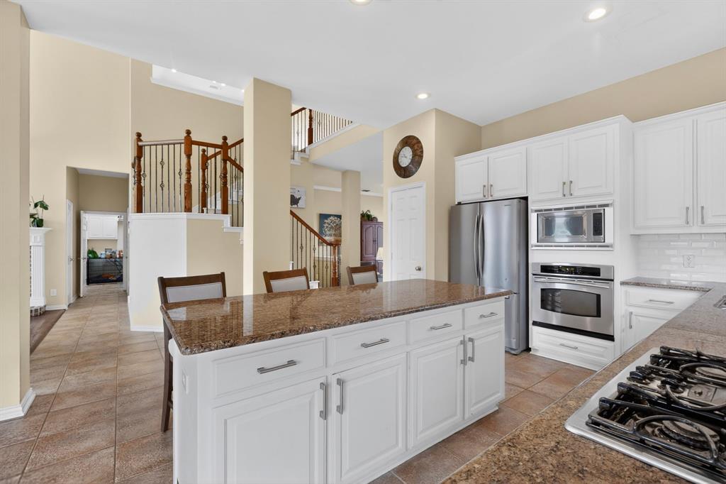 4004 White Porch Road Plano, TX 75024 - Photo 14 of 40 a kitchen with stainless steel appliances granite countertop a stove a sink and a refrigerator