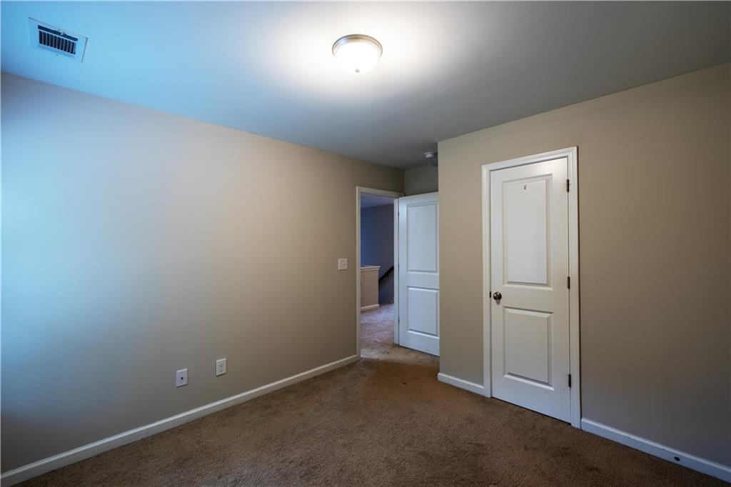 221 Winterset Circle Hoschton, GA 30548 - Photo 21 of 23 an empty room with closet and a window