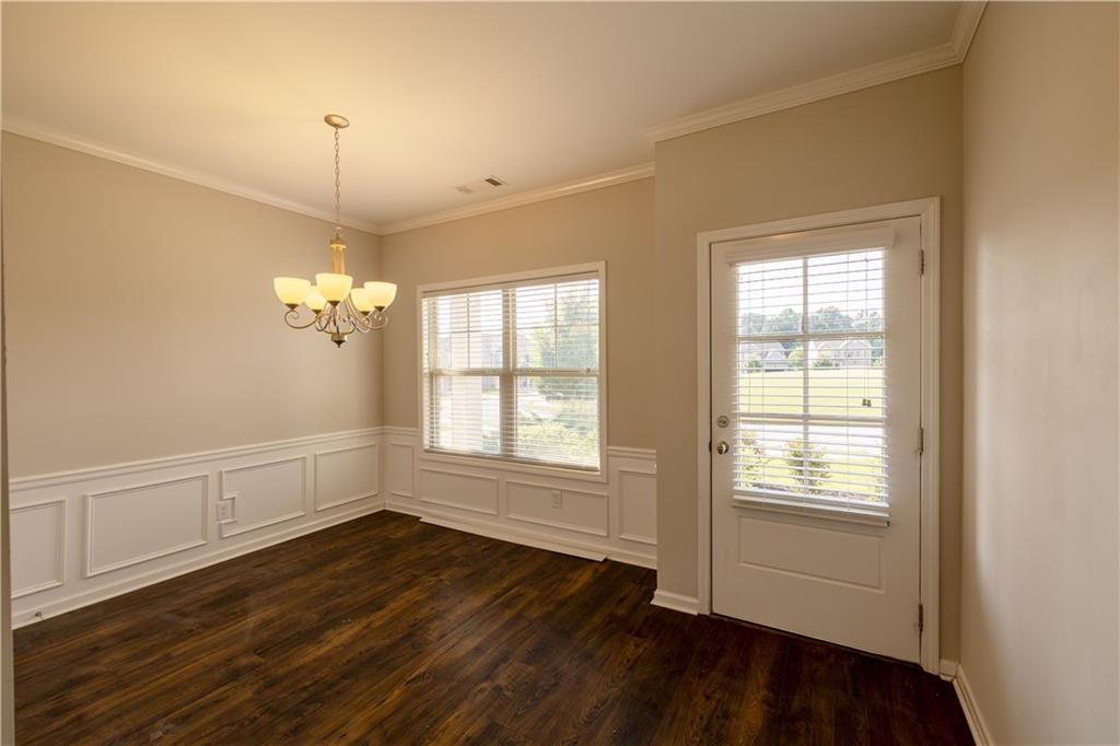221 Winterset Circle Hoschton, GA 30548 - Photo 4 of 23 a view of an empty room with wooden floor and a window