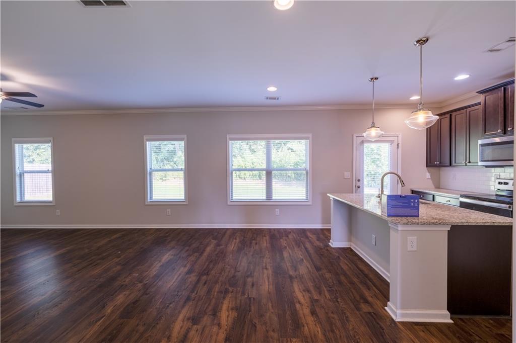 221 Winterset Circle Hoschton, GA 30548 - Photo 6 of 23 a open kitchen with cabinets wooden floor and stainless steel appliances