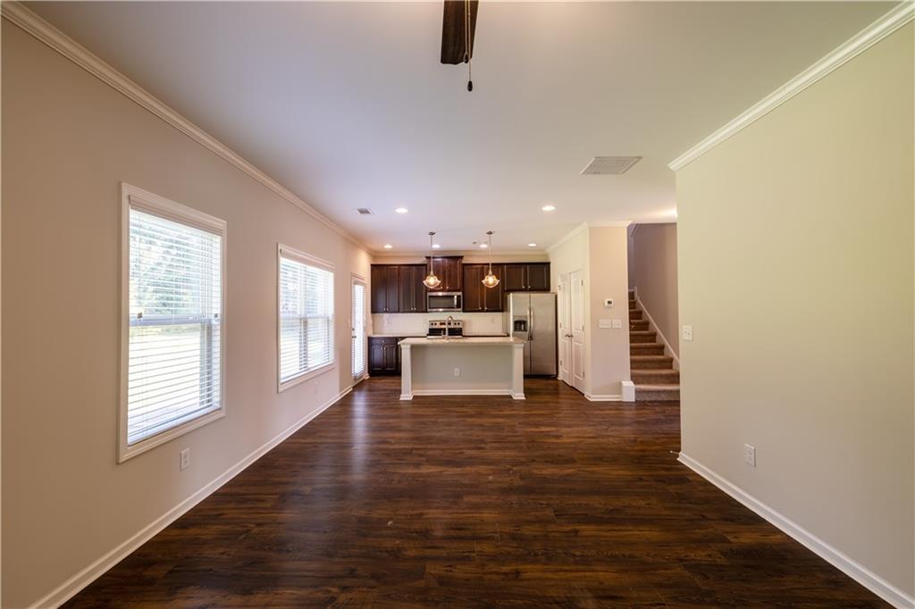 221 Winterset Circle Hoschton, GA 30548 - Photo 8 of 23 a view of a kitchen with kitchen island stainless steel appliances wooden floor and window