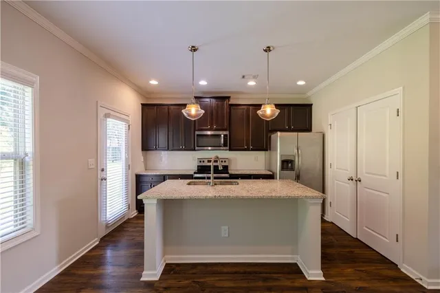 a view of kitchen with refrigerator microwave and stove