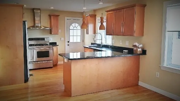 a kitchen with stainless steel appliances granite countertop a stove a sink and a refrigerator