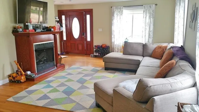 a living room with furniture a fireplace and a large mirror