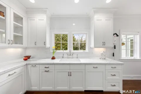a kitchen with cabinets appliances a sink and a window