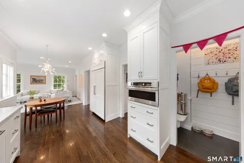 a kitchen with stainless steel appliances kitchen island granite countertop a table chairs and a refrigerator
