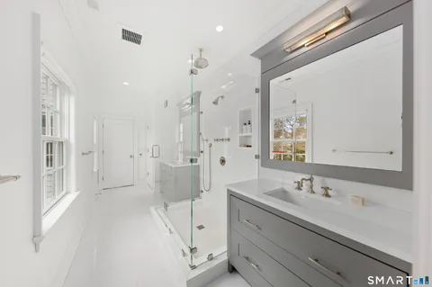 a bathroom with a double vanity sink a mirror and a shower