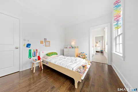 a bedroom with a bed and wooden floor