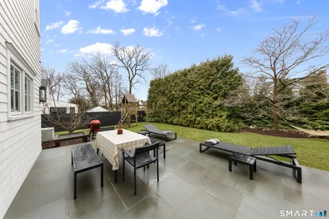 a backyard view of a house with outdoor seating