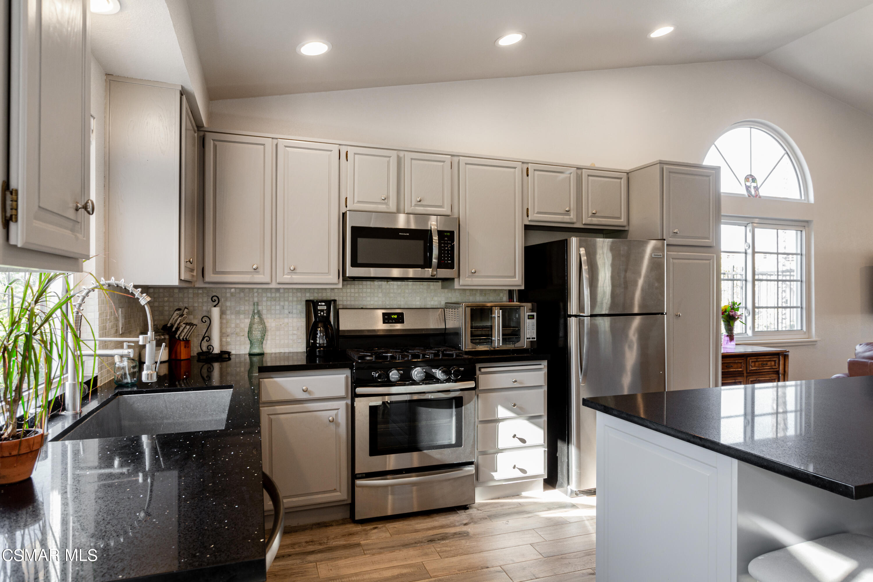 4249 Laurelhurst Road Moorpark, CA 93021 - Photo 11 of 30 a kitchen with granite countertop a refrigerator a stove a sink a dining table and chairs