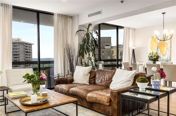 a dining room with furniture potted plants and wooden floor