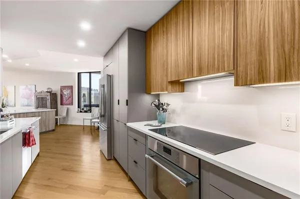 a view of a kitchen with kitchen island granite countertop a sink and a wooden floor