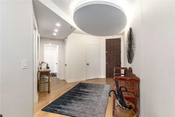 a view of a hallway with wooden floor and a bathroom