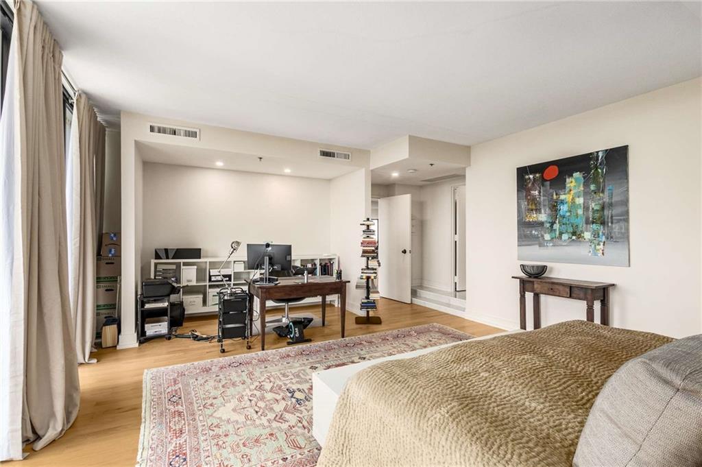 2660 Peachtree Road Northwest, Unit 18H Atlanta, GA 30305 - Photo 23 of 61 a bed room with a bed and a chair