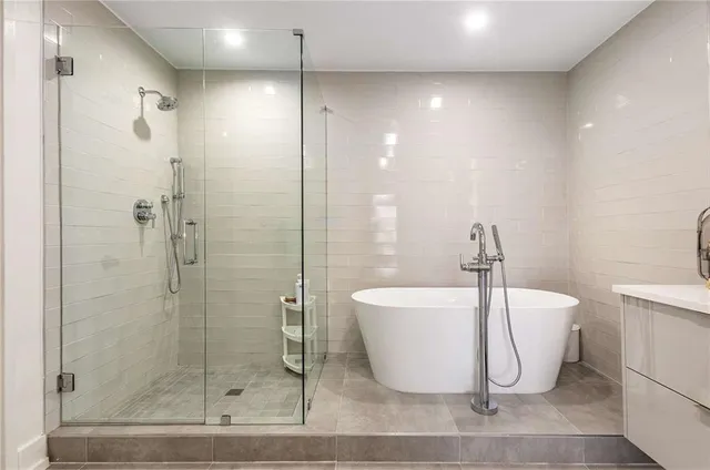 a bathroom with a double vanity sink a mirror and a bathtub