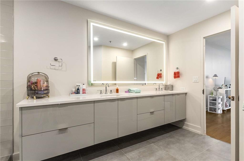 2660 Peachtree Road Northwest, Unit 18H Atlanta, GA 30305 - Photo 30 of 61 a bathroom with a double vanity sink and a mirror