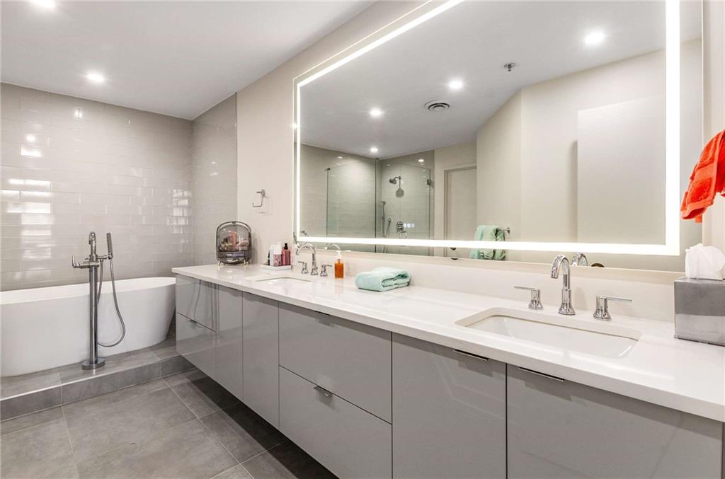2660 Peachtree Road Northwest, Unit 18H Atlanta, GA 30305 - Photo 31 of 61 a bathroom with a double vanity sink a mirror and a bathtub