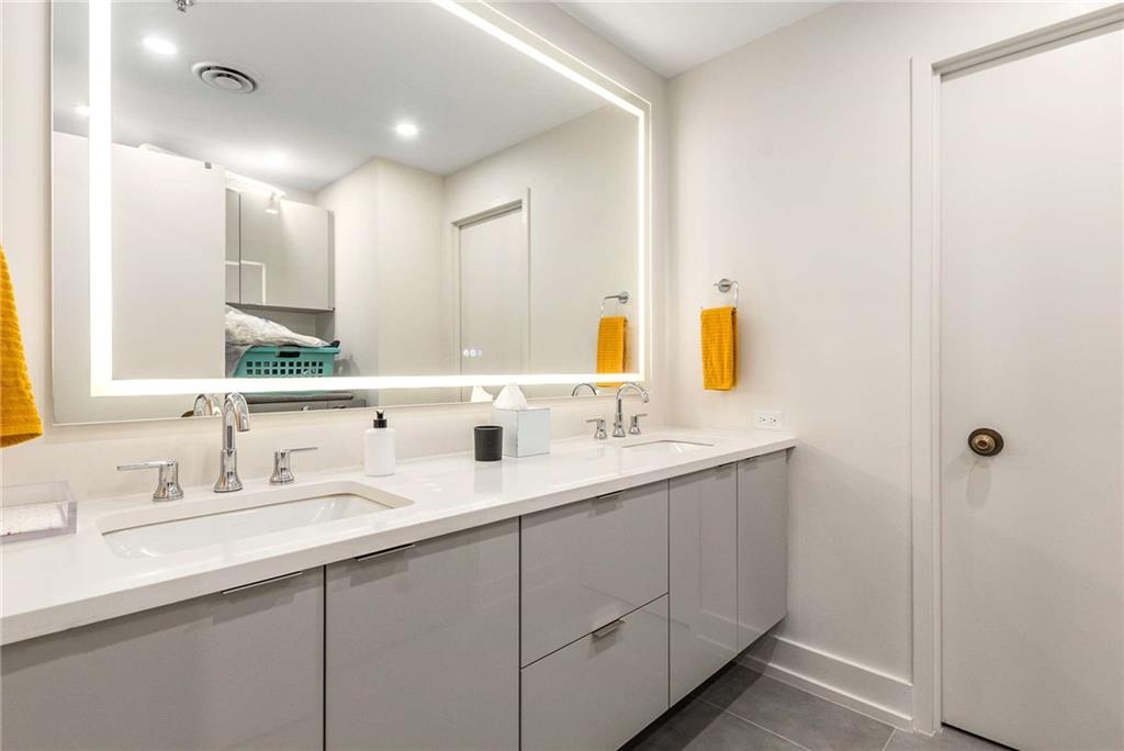 2660 Peachtree Road Northwest, Unit 18H Atlanta, GA 30305 - Photo 33 of 61 a bathroom with a double vanity sink and mirror