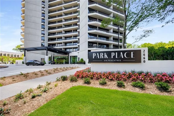 a view of building with yard and trees in the background