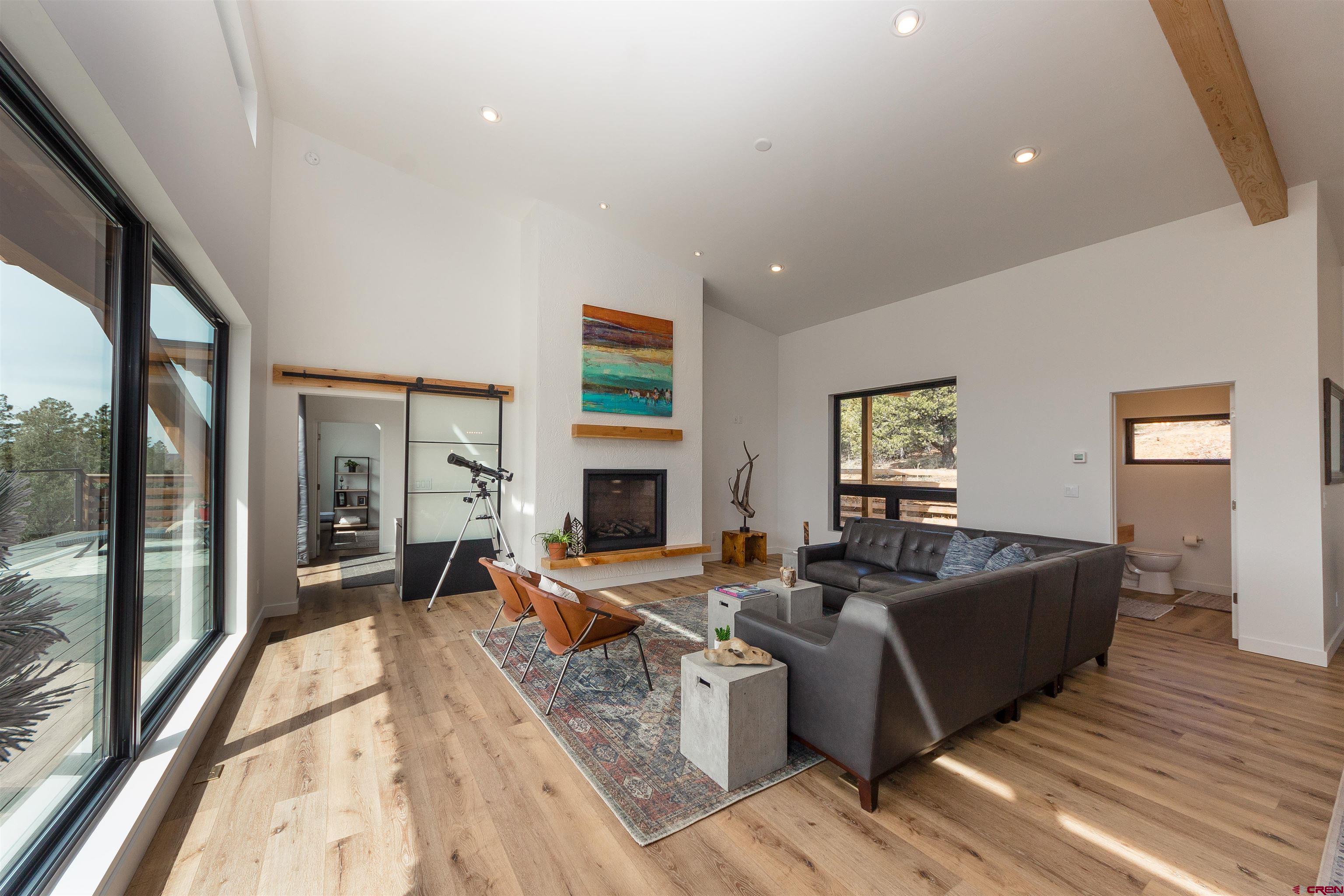 405 Far View Road Durango, CO 81303 - Photo 13 of 35 a living room with fireplace furniture and a large window