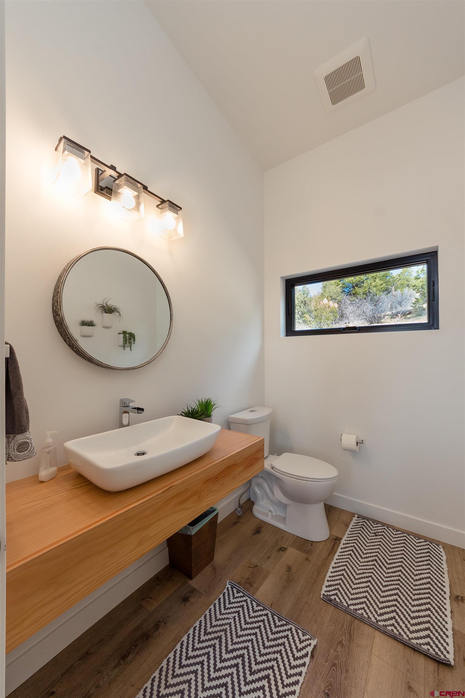 405 Far View Road Durango, CO 81303 - Photo 16 of 35 a bathroom with a granite countertop toilet a sink and a mirror