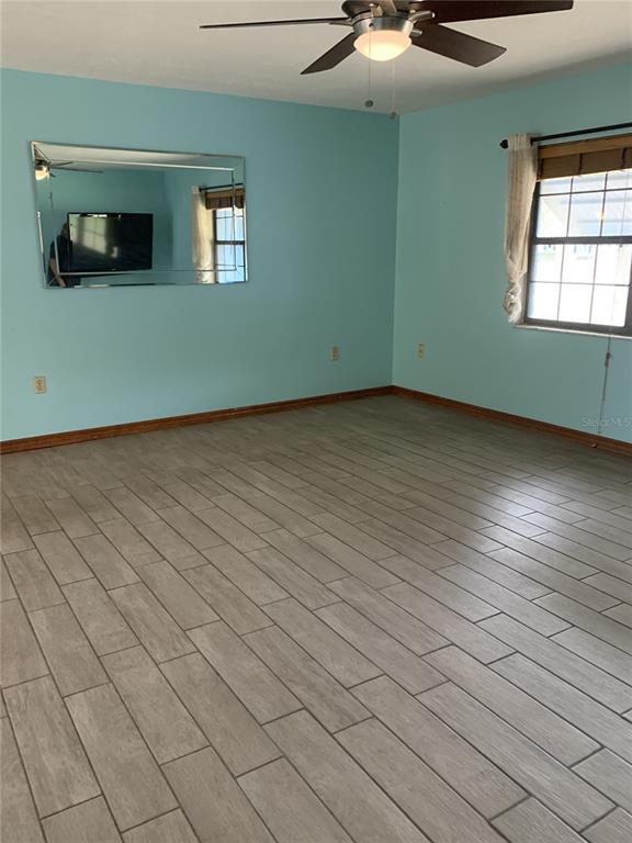 5140 Courtland Road Spring Hill, FL 34608 - Photo 5 of 20 an empty room with wooden floor and windows