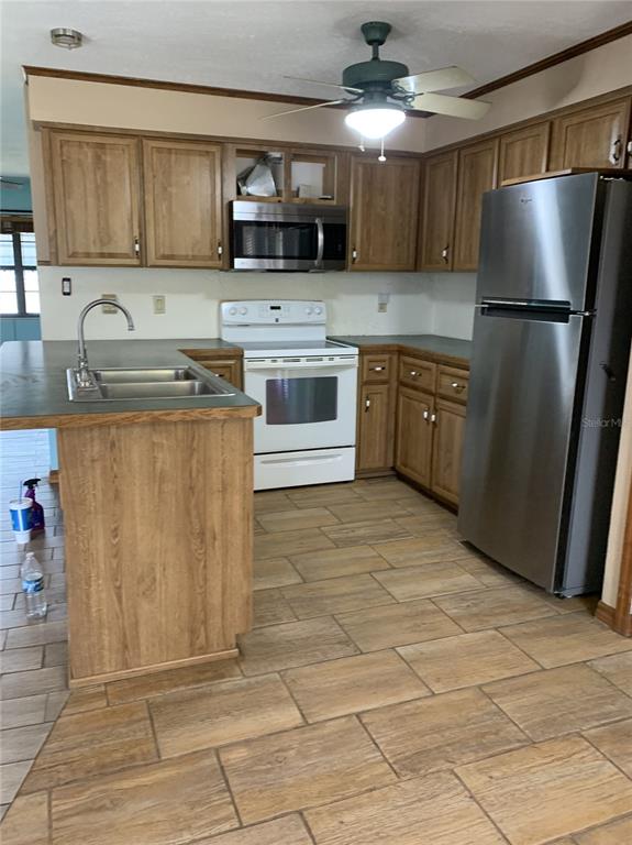 5140 Courtland Road Spring Hill, FL 34608 - Photo 7 of 20 a kitchen with stainless steel appliances granite countertop a refrigerator a stove a sink and a microwave