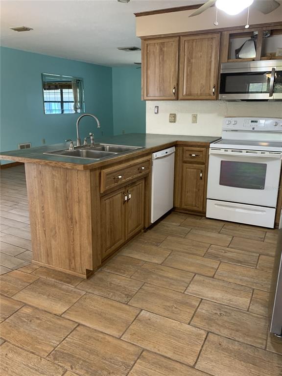 5140 Courtland Road Spring Hill, FL 34608 - Photo 8 of 20 a kitchen with stainless steel appliances granite countertop a sink stove and cabinets