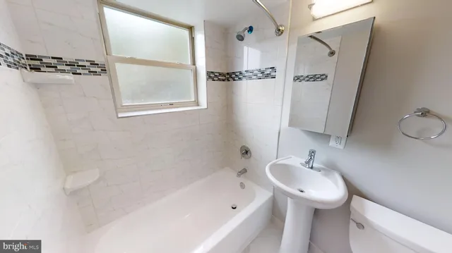 a white toilet sitting next to a bath tub