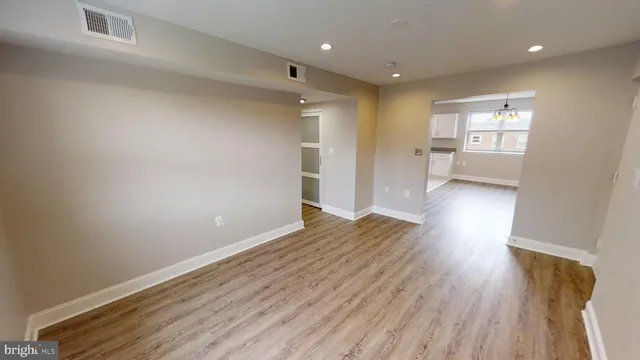 a kitchen with wooden floors and white walls