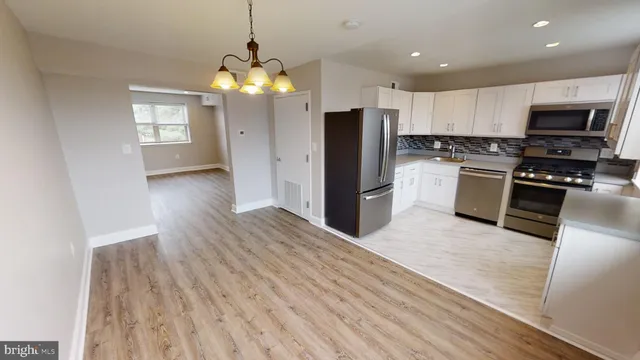 a kitchen with granite countertop a stove top oven microwave and cabinets