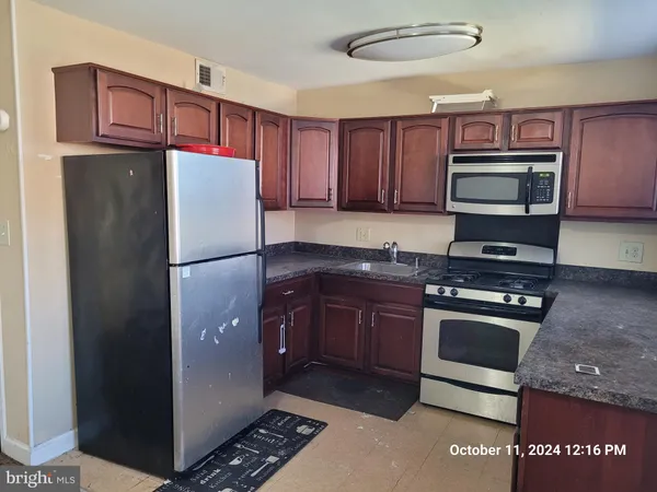 a kitchen with stainless steel appliances granite countertop a stove a sink and a refrigerator