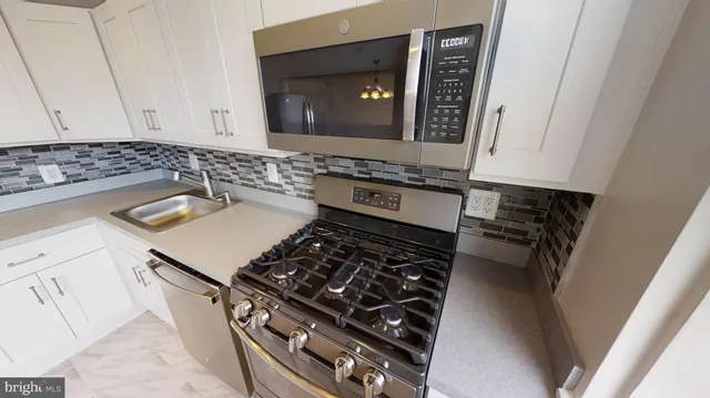 a kitchen with stainless steel appliances a refrigerator a stove a microwave and cabinets