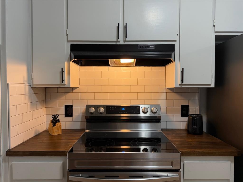 508 Batterson Street Cleburne, TX 76031 - Photo 11 of 28 Kitchen featuring a stainless steel electric range, white subway tile backsplash, and wood-finish countertops