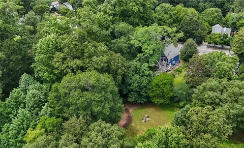 an aerial view of residential house with outdoor space and trees around