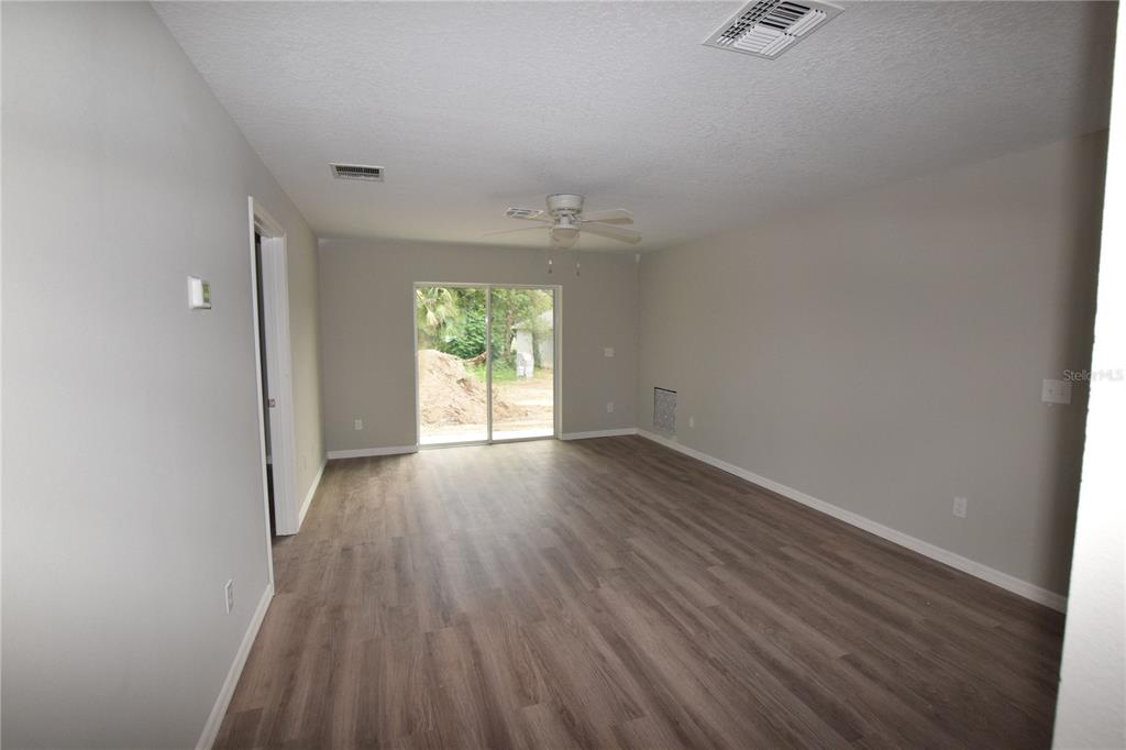 935 East McDonald Avenue Eustis, FL 32726 - Photo 3 of 12 an empty room with wooden floor and windows