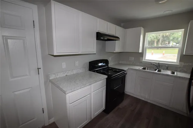 a kitchen with a sink a refrigerator and window