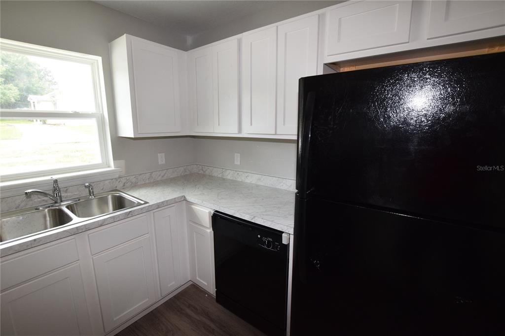935 East McDonald Avenue Eustis, FL 32726 - Photo 7 of 12 a kitchen with a sink and a refrigerator