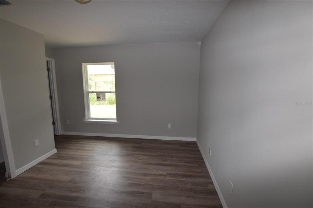 935 East McDonald Avenue Eustis, FL 32726 - Photo 9 of 12 a view of an empty room with wooden floor and a window