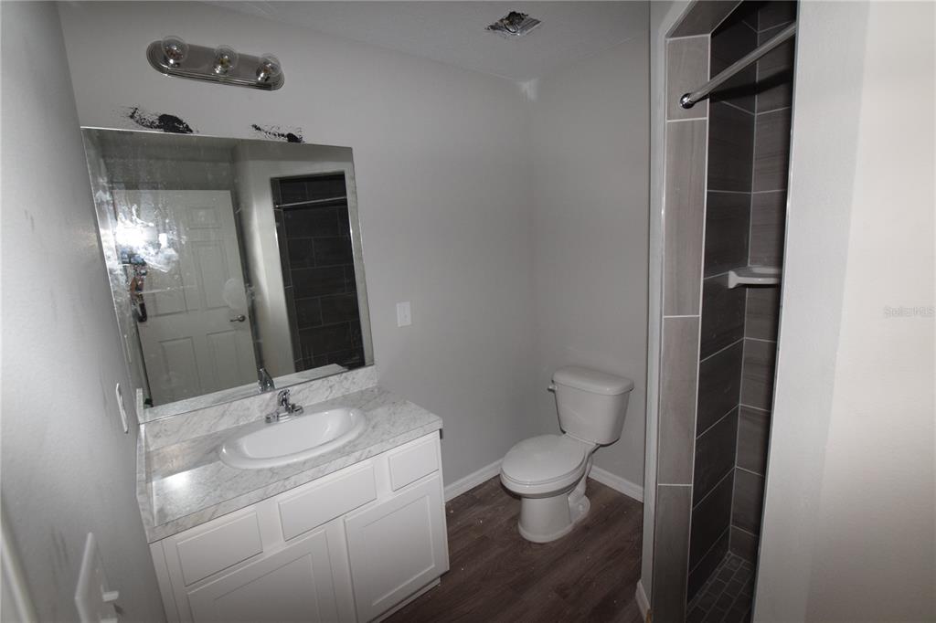 935 East McDonald Avenue Eustis, FL 32726 - Photo 10 of 12 a bathroom with a toilet sink and mirror