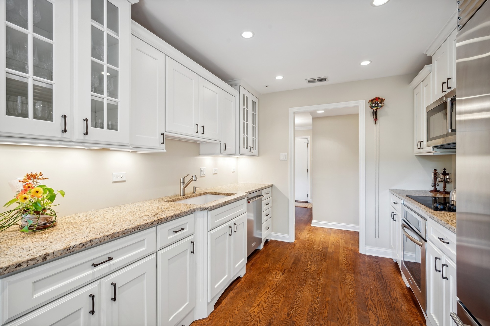 1125 Lake Cook Road, Unit 404E Northbrook, IL 60062 - Photo 8 of 18 a kitchen with granite countertop a sink stainless steel appliances white cabinets and a window