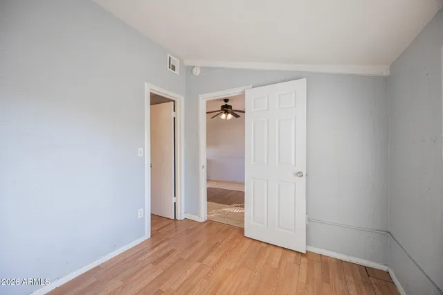 an empty room with wooden floor and closet