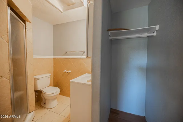 a white toilet sitting next to a shower