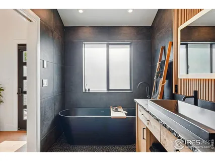 a spacious bedroom with a bed a couch and a potted plant