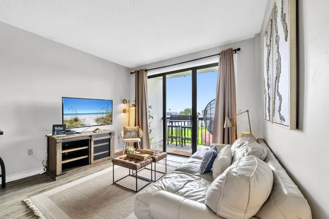 a living room with furniture and a floor to ceiling window