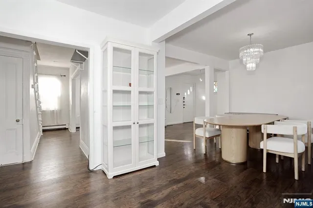 a view of a room with wooden floor and kitchen view