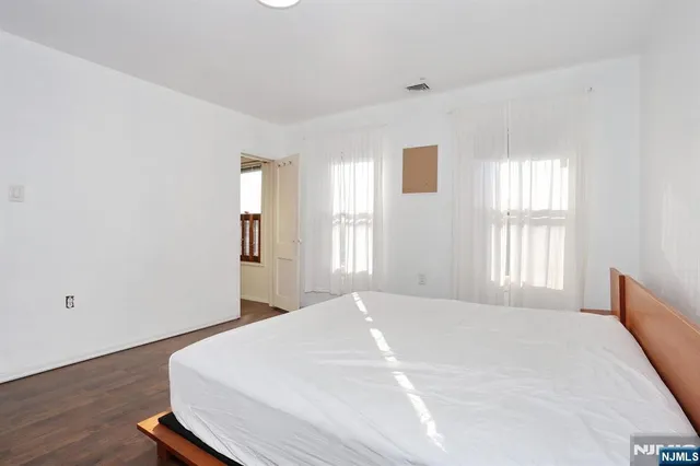 a bedroom with a bed and a large window