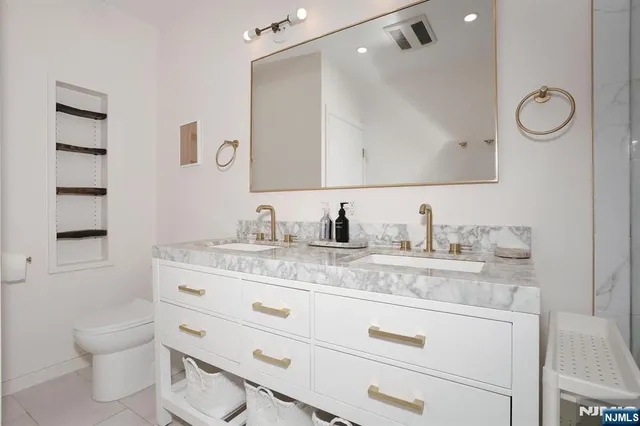 a bathroom with a granite countertop toilet sink and mirror
