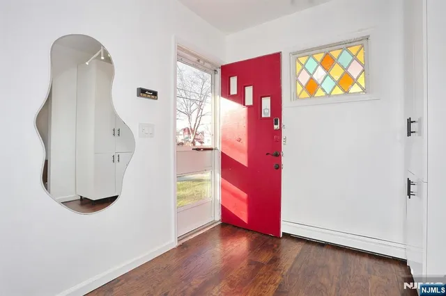 an entryway at room with wooden floor and windows